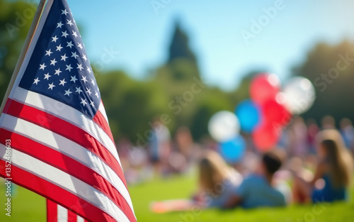 Group of people, large family on green lawn in park for picnic on sunny day, celebrating Independence Day, Fourth of July. American flag in foreground, symbolizing patriotism and national pride