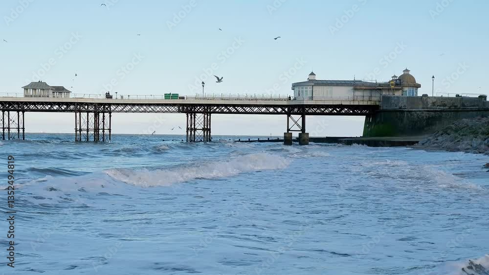 Panning shot across Cromer Beach and the Victorian pier. Captured at high tide during late afternoon as the sun starts to set Panning shot across Cromer Beach and the Victorian pier. Captured at high tide during late afternoon as the sun starts to set