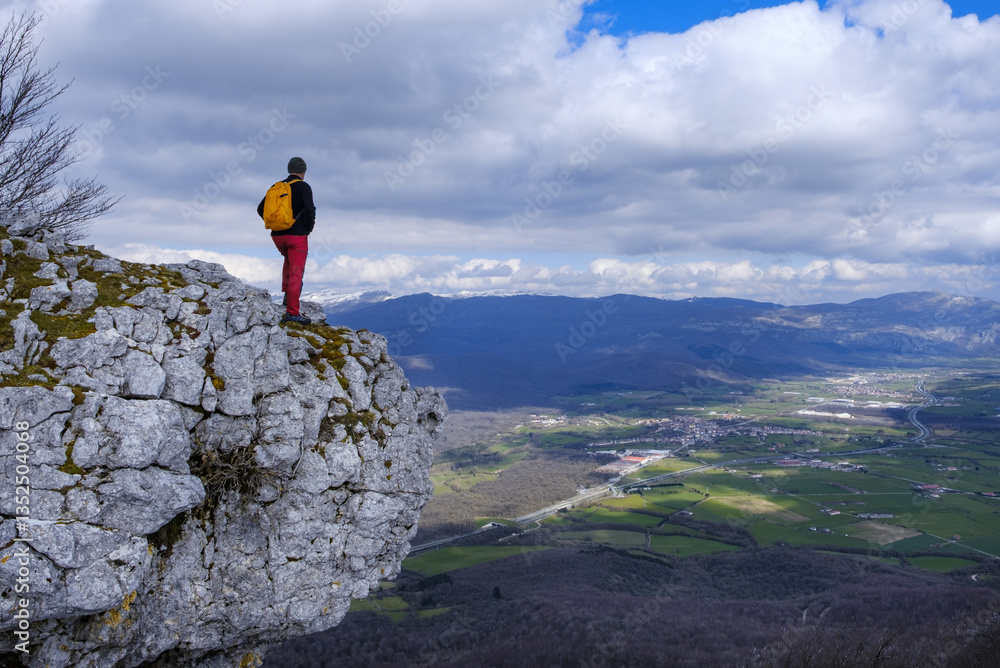 Hiker in the Sierra de Urbasa with the Sakana valley in the background, Navarra, Spain.