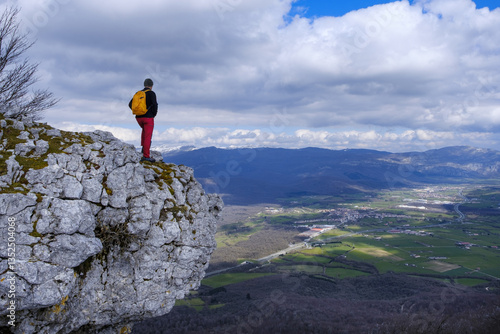 Hiker in the Sierra de Urbasa with the Sakana valley in the background, Navarra, Spain.