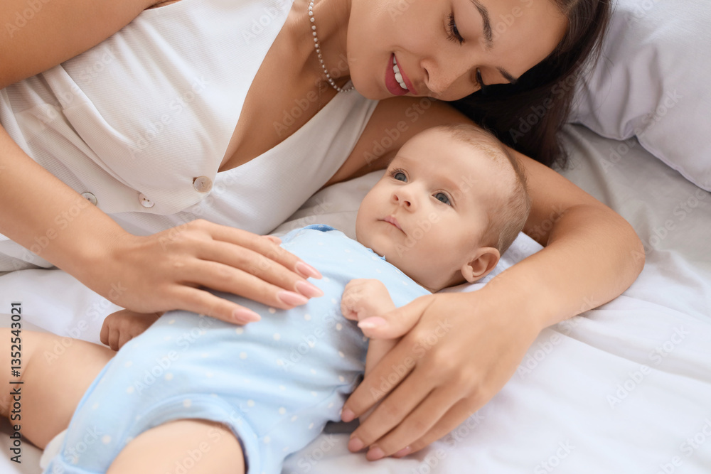 Beautiful young happy Asian mother with her cute little baby lying on bed at home Beautiful young happy Asian mother with her cute little baby lying on bed at home