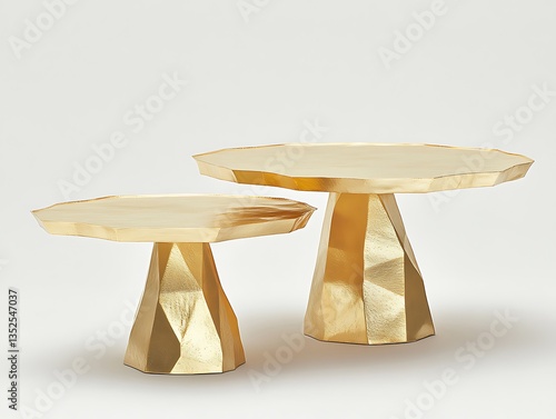 Two golden pedestal tables displayed on a white background