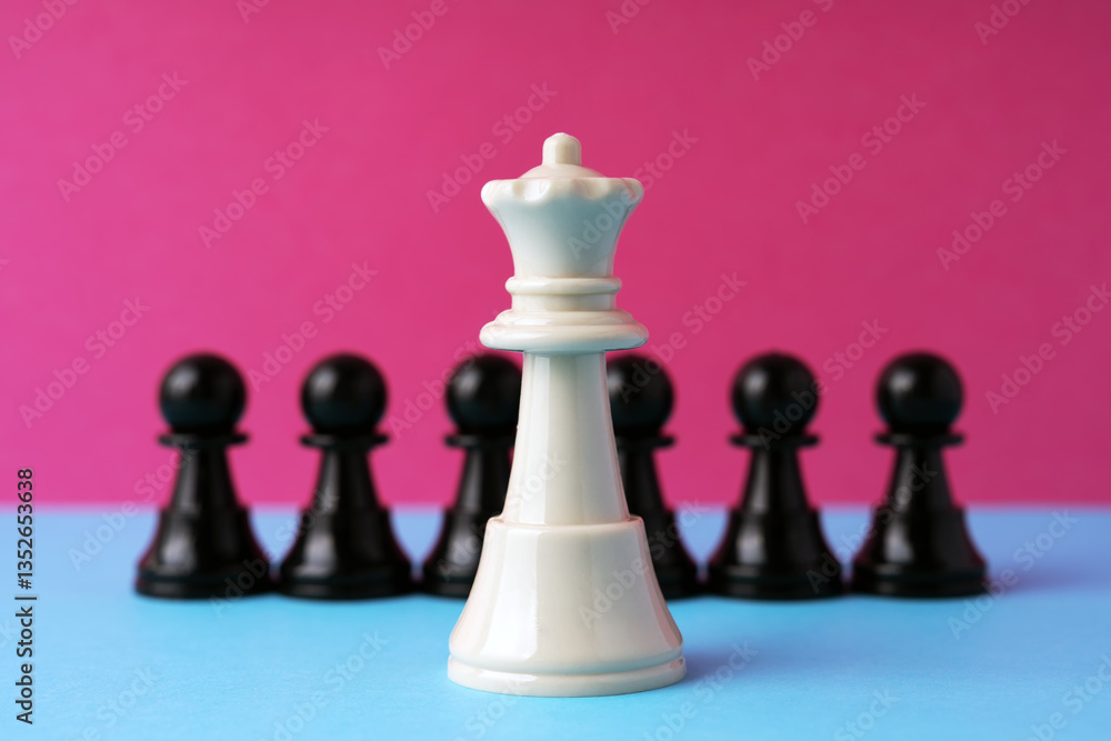 White queen chess in front of black pawn on pink background White queen chess in front of black pawn on pink background