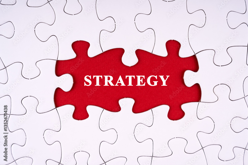 Strategy written on red background through a non completed white blank puzzle Strategy written on red background through a non completed white blank puzzle