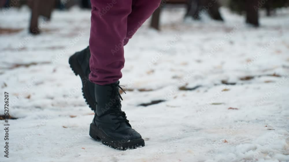 Side view of person wearing black boots jumping from right to left on snow-covered ground, winter setting highlights movement, rugged footwear, and crisp seasonal atmosphere Side view of person wearing black boots jumping from right to left on snow-covered ground, winter setting highlights movement, rugged footwear, and crisp seasonal atmosphere