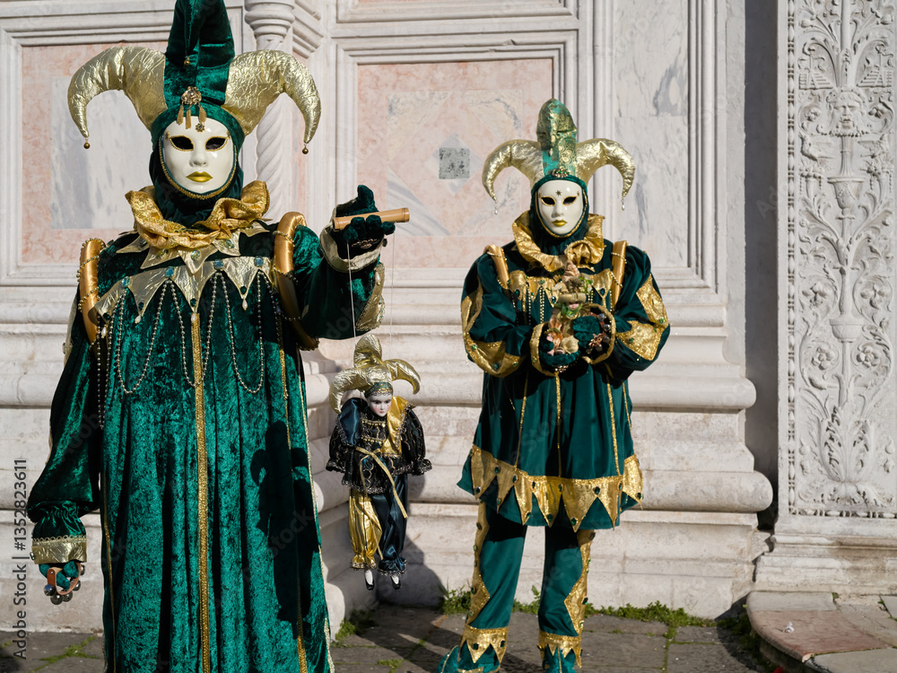 Obraz premium Venice, Italy - People dressed in carnival masks are photographed by tourists in the scenery of the ancient Venetian palaces