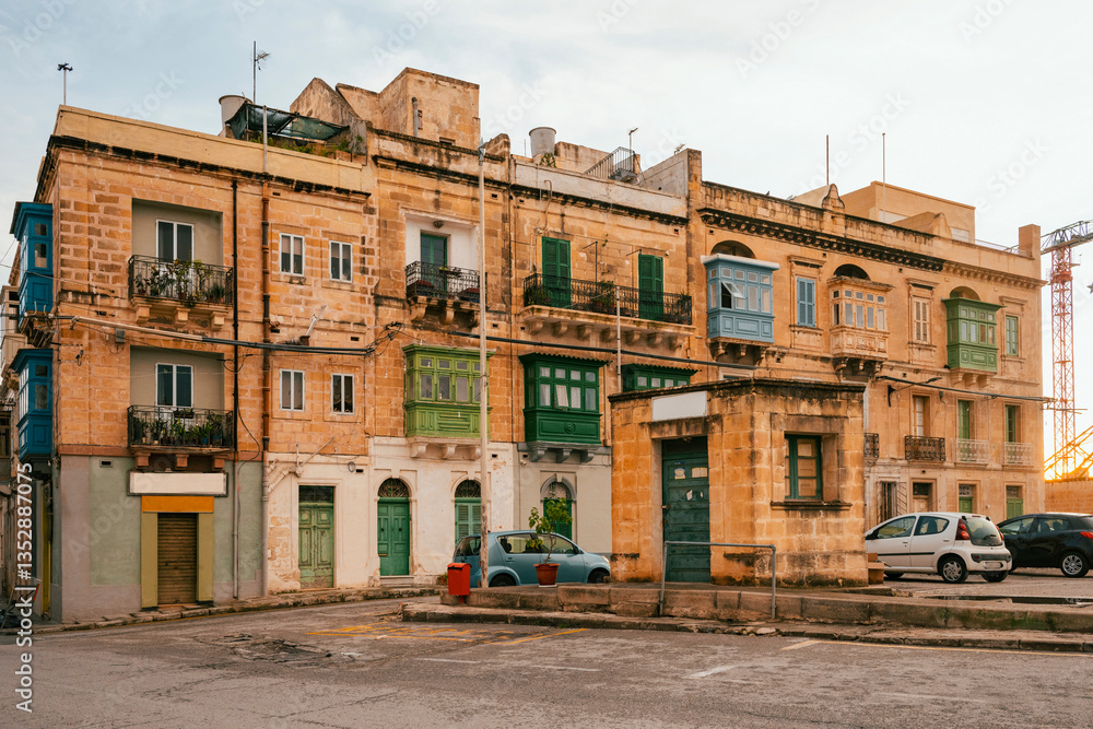 Naklejka premium The nearly empty St. Margaret Street in Cospicua. Perhaps a reflection of the times. Triq Santa Margerita, Bormla.Cospicua,View at St Paul's Church Cospicua through a street with many colorful bay