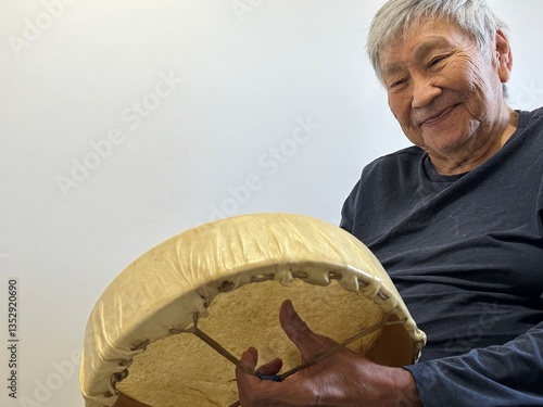 indigenous, senior male tapping his drum