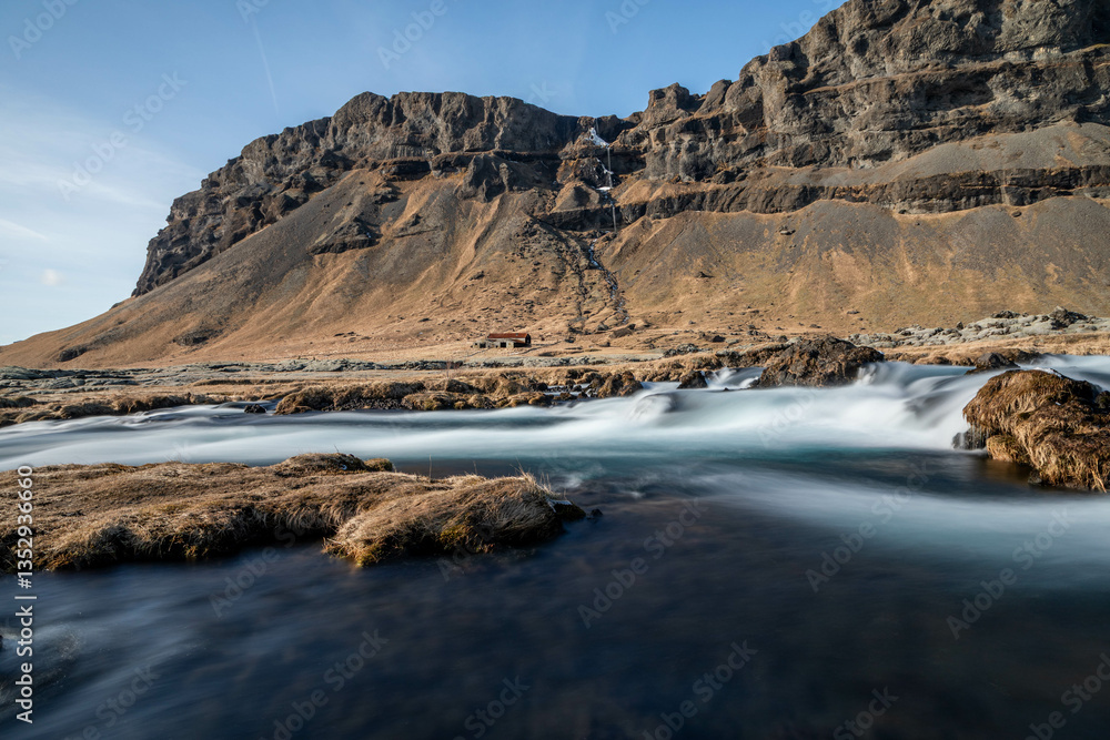 Obraz premium a small river in the south of Iceland with an old barn in the background