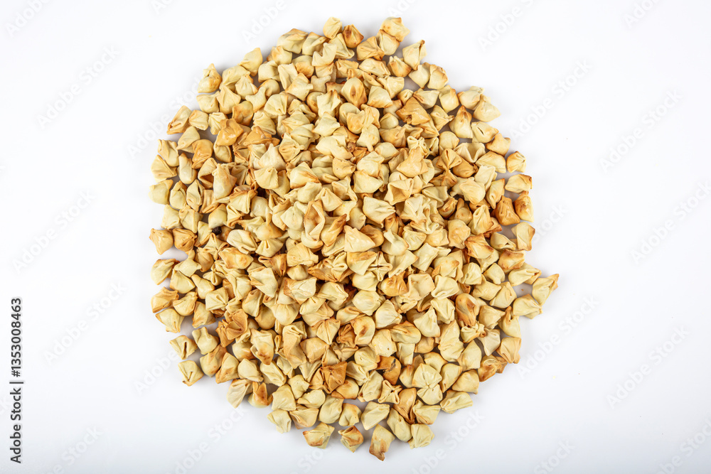 Turkish Ravioli manti. In dried form. On the plate. Ravioli scattered around. Isolated shot from top angle. Studio shoot. Turkish Ravioli manti. In dried form. On the plate. Ravioli scattered around. Isolated shot from top angle. Studio shoot.