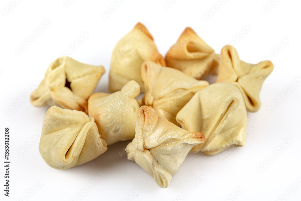 Turkish Ravioli manti. In dried form. On the plate. Ravioli scattered around. Isolated shot from top angle. Studio shoot. Turkish Ravioli manti. In dried form. On the plate. Ravioli scattered around. Isolated shot from top angle. Studio shoot.