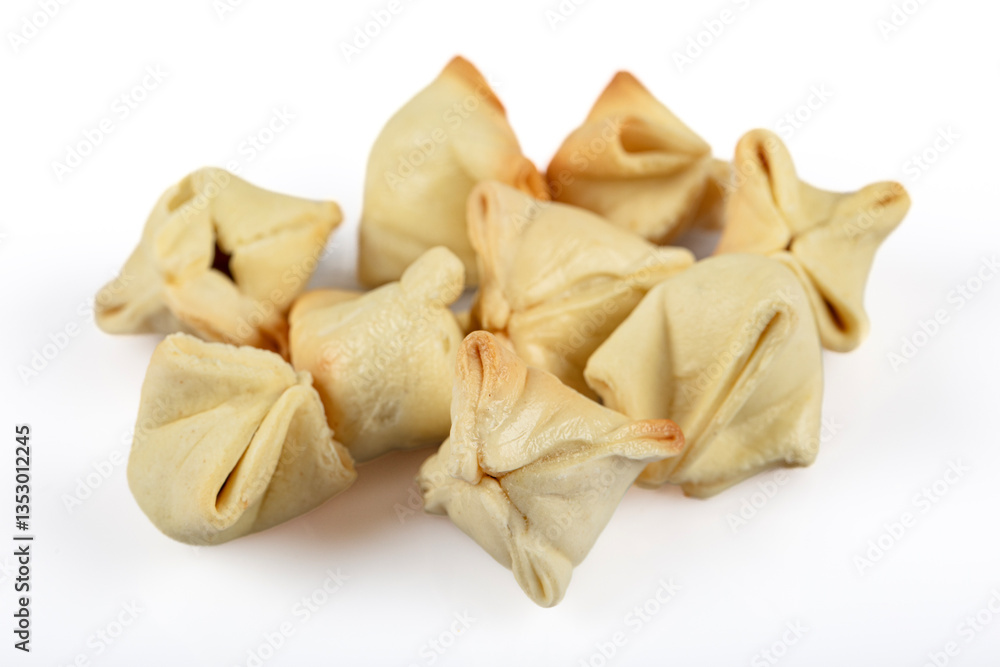 Turkish Ravioli manti. In dried form. On the plate. Ravioli scattered around. Isolated shot from top angle. Studio shoot. Turkish Ravioli manti. In dried form. On the plate. Ravioli scattered around. Isolated shot from top angle. Studio shoot.