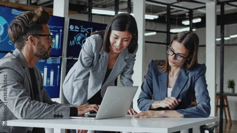 Three professionals analyzing digital data in modern office workspace, engaged in collaborative discussion around laptop with analytics screens in background Three professionals analyzing digital data in modern office workspace, engaged in collaborative discussion around laptop with analytics screens in background