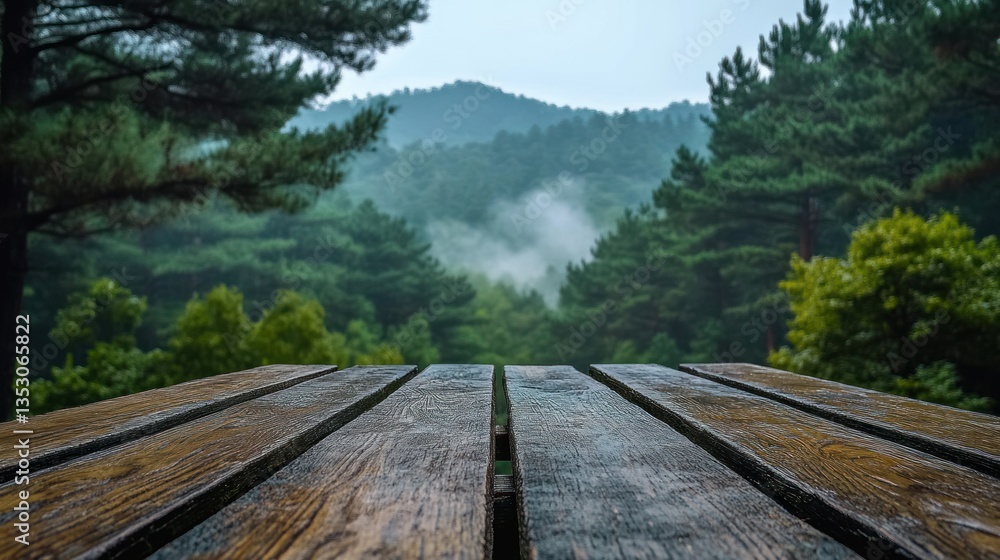Obraz premium Wooden picnic table overlooking misty mountain forest