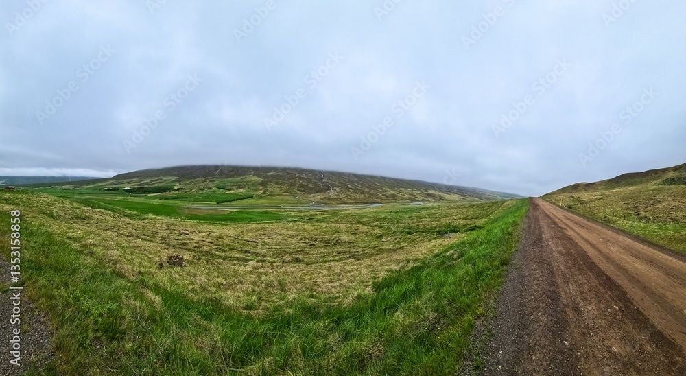Fototapeta premium Panoramic view of gravel road crossing icelandic fields and hills