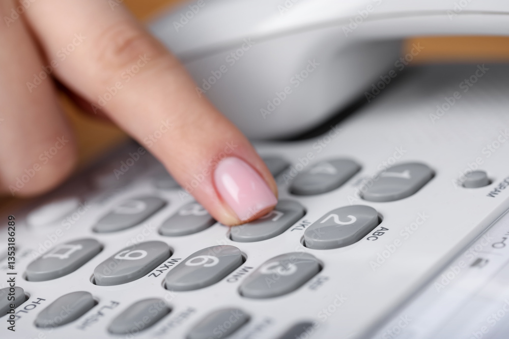 Woman dialing number on landline telephone, closeup Woman dialing number on landline telephone, closeup