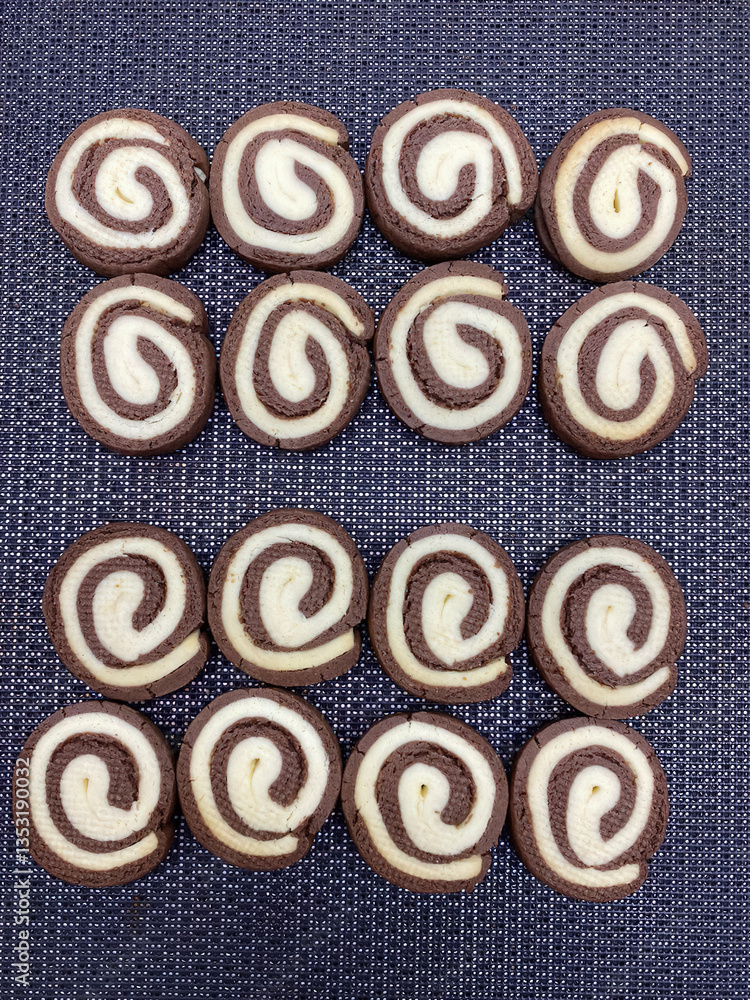 Circular cookies are perfectly arranged in rows displaying a delightful combination of chocolate and vanilla flavors Circular cookies are perfectly arranged in rows displaying a delightful combination of chocolate and vanilla flavors
