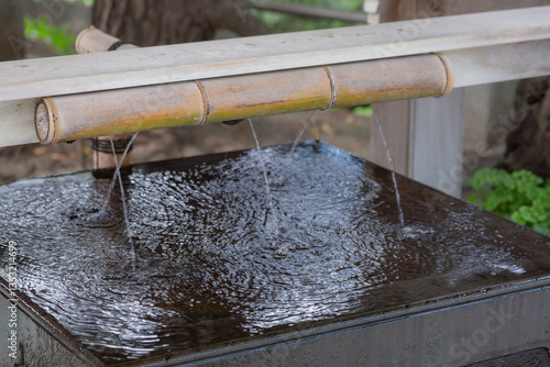 water flowing out from bamboo at water purification place called chozuya in matsudo shrine