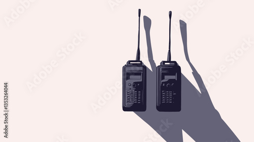 High-angle, close-up view of two dark-grey or black walkie-talkies positioned on a bright white background. The walkie-talkies are slightly separated, with their antennas extending upwards.  A