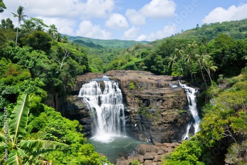 A beautiful waterfall cascades surrounded by lush tropical green foliage