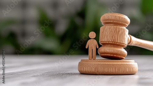 A wooden gavel next to a human figure, symbolizing justice and law.
