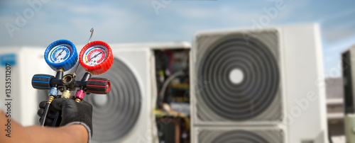 Fotografie Electrical technician use manifold gauge check and filling refrigerant vacuum pump evacuates industry air conditioning HAVC system maintenance or chiller and air conditioner cleaning filter service