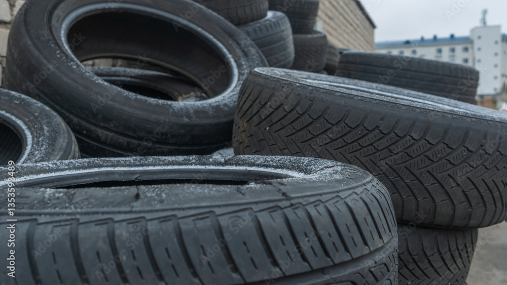 Obraz premium Close-up view of discarded old car tires outdoors, showcasing a pile of used tires ready for recycling. Highlighting environmental concerns and rubber waste management
