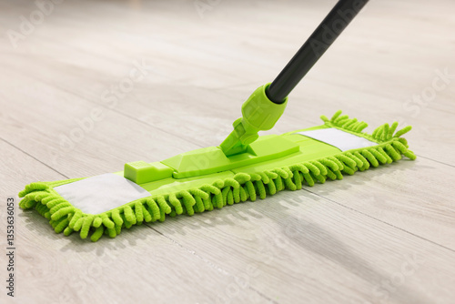 фотографія Microfiber mop on wooden floor, closeup. Cleaning equipment