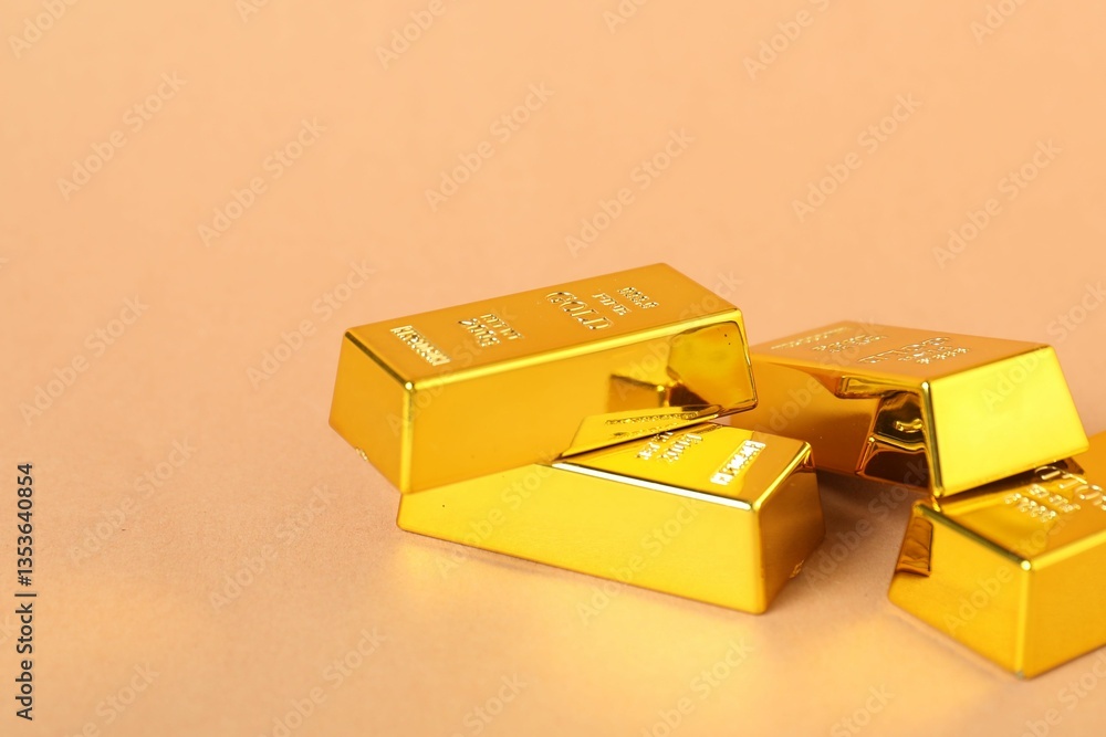 Shiny gold bars on light coral background, closeup. Space for text Shiny gold bars on light coral background, closeup. Space for text