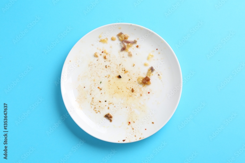 One dirty plate on light blue background, top view One dirty plate on light blue background, top view