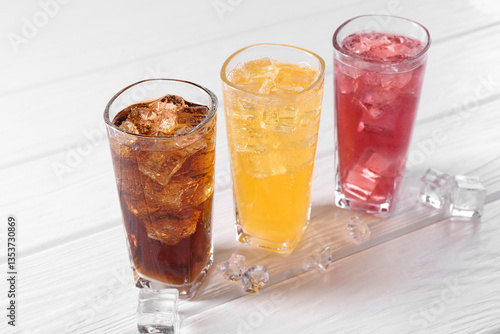 Wallpaper Mural Soda water of different flavors in glasses with ice cubes on white wooden table Torontodigital.ca