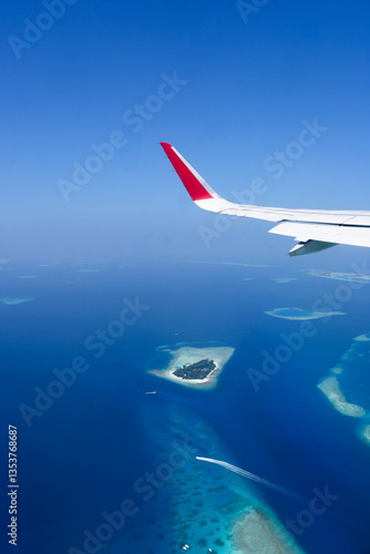 Scenery view of Maldives islands top view from airplane wing flying in the blue sky above Maldives island