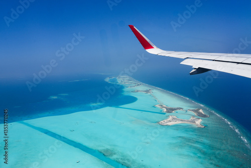 Scenery view of Maldives islands top view from airplane wing flying in the blue sky above Maldives island