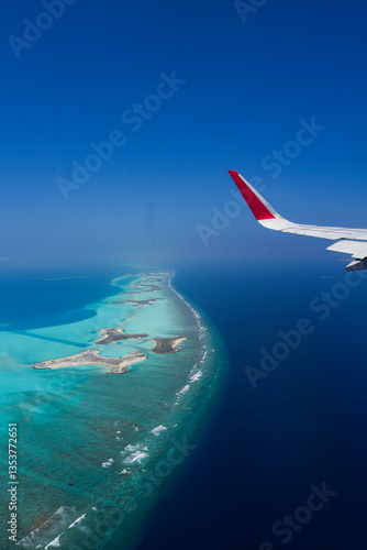 Scenery view of Maldives islands top view from airplane wing flying in the blue sky above Maldives island
