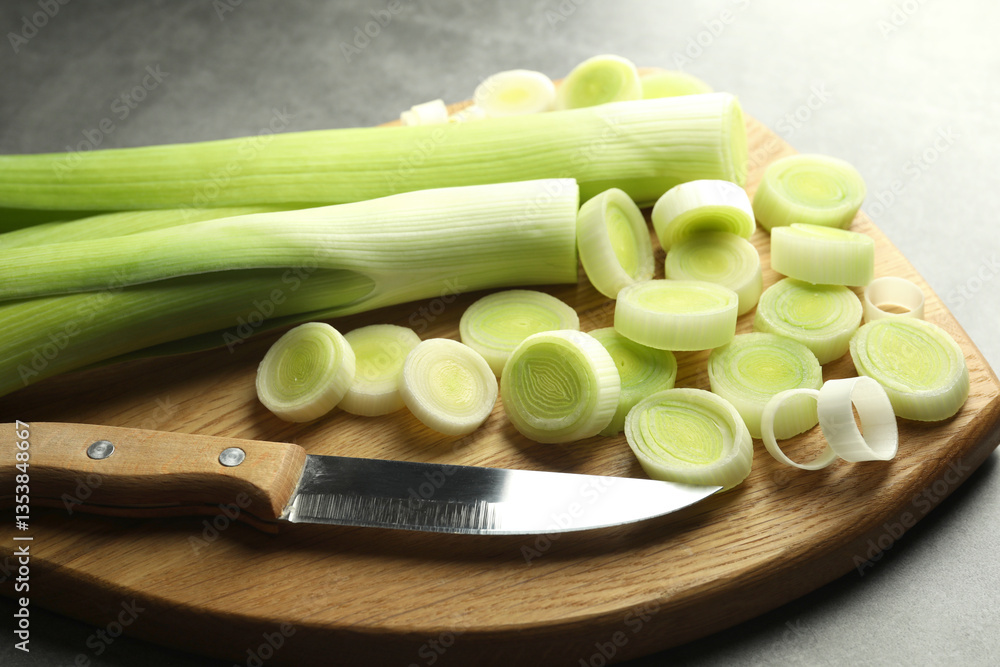 Chopped leeks and knife on grey table, closeup Chopped leeks and knife on grey table, closeup