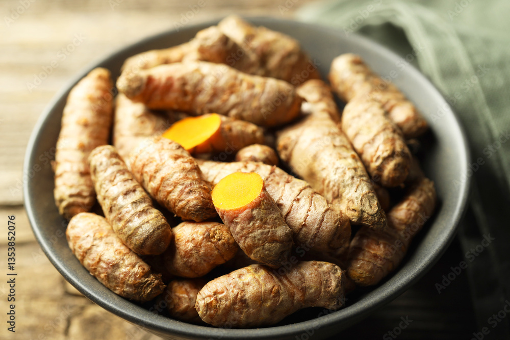 Fototapeta premium Tumeric rhizomes in bowl on table, closeup