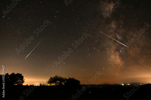 Obraz na płótnie Milky way stars, meteor trails and landscape silhouettes. w salonie
