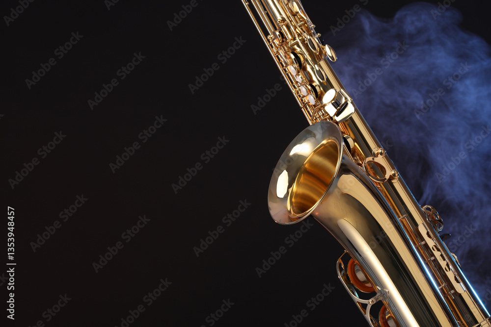 Obraz premium Golden saxophone on black background with smoke, closeup. Space for text