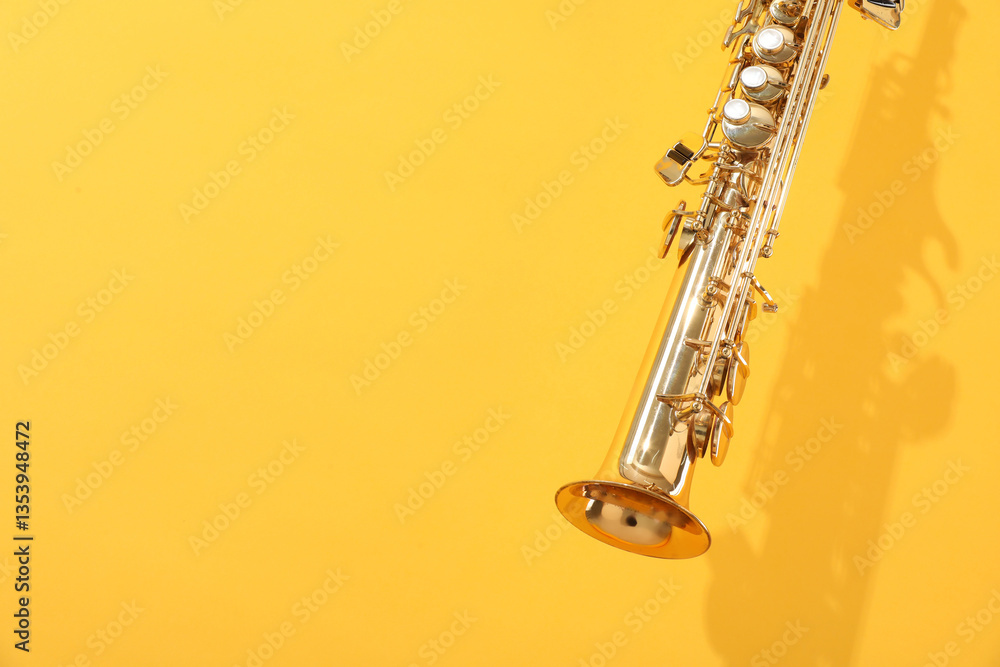 Naklejka premium Golden soprano saxophone on yellow background, closeup. Space for text