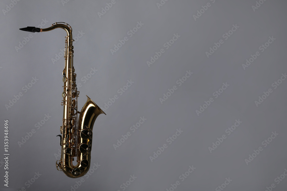 Naklejka premium Golden saxophone on grey background. Space for text