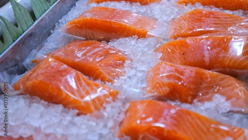 Fresh salmon fillets, individually wrapped in plastic, lay chilling on a bed of ice, ready for purchase at a fish market, promising a delicious and healthy meal. Fresh fish on the market