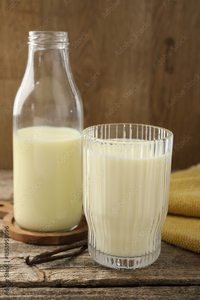 Delicious vanilla milk and pods on wooden table Delicious vanilla milk and pods on wooden table
