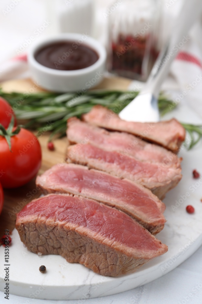 Delicious sliced beef tenderloin with different degrees of doneness, tomatoes and spices on table, closeup Delicious sliced beef tenderloin with different degrees of doneness, tomatoes and spices on table, closeup