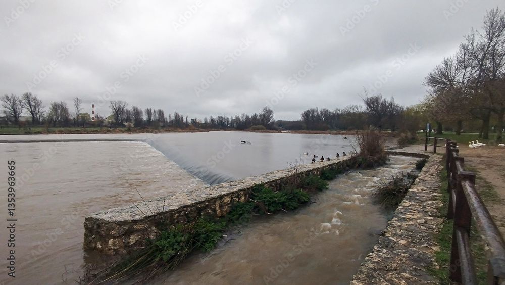 Fototapeta premium Crecida de río por abundantes lluvias un día lluvioso en Burgos, España