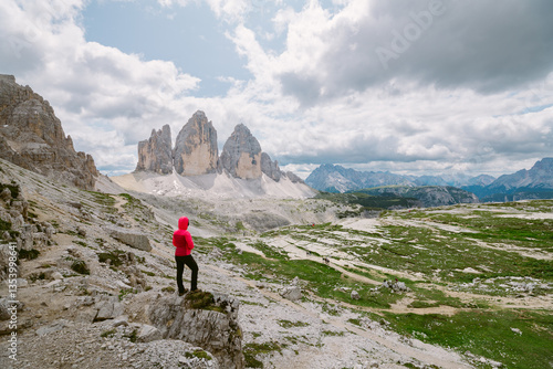 Hiker admires Tre Cime di Lavaredo, Dolomites.