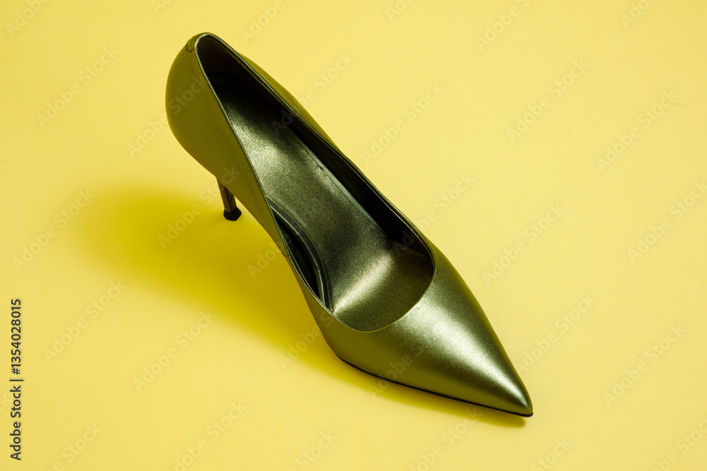 Green high hill shoe against yellow background.