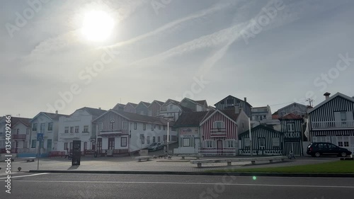 Aveiro, Portugal - February 20, 2025: Colorful striped houses in Costa Nova, Portugal, under a bright sky, showcasing traditional architecture in a charming coastal village atmosphere.
