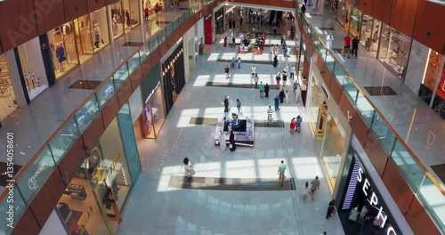 Timelapse of busy Dubai mall shopping center with several floors and stores, tourist people walking and shopping