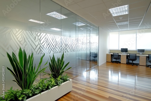 A modern workspace with etched glass partitions outlining team zones, complemented by sleek wood floors and subtle greenery for a calm ambiance