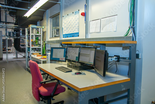 Foto Industrial control room with multi-monitor workstation for real-time system anal